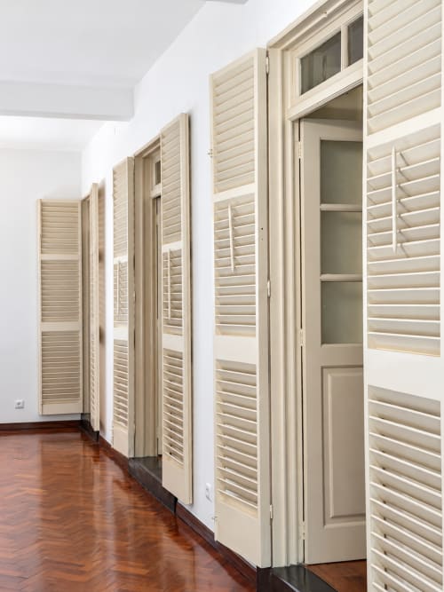Beige louvered closet doors line hallway with wooden floor at Check Madeira hotel, Ribeira Brava