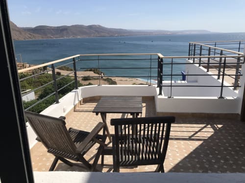 Tagante room terrace at Imsouane Surf Paradise with sea view, dining table, and Moroccan coastal landscape