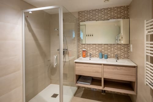 Salle de bains moderne du Domaine Des Escouanes avec double vasque, douche à l'italienne et dosseret géométrique