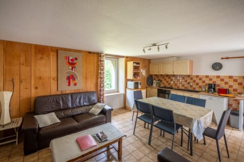 Burley cottage at Domaine Des Escouanes with open-plan living area, wooden cabinets, leather sofa, and dining table