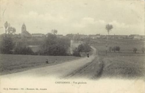 Panorama champêtre de Chevannes avec château au loin et route rurale sinueuse traversant les terres agricoles
