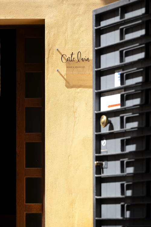 Ingresso del B&B Corte Livia a Forlì con muro in intonaco giallo, porta in legno e cassette postali