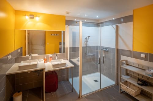 Salle de bain moderne du Domaine Des Escouanes avec murs jaunes, double vasque et douche à l'italienne, Prudhomat