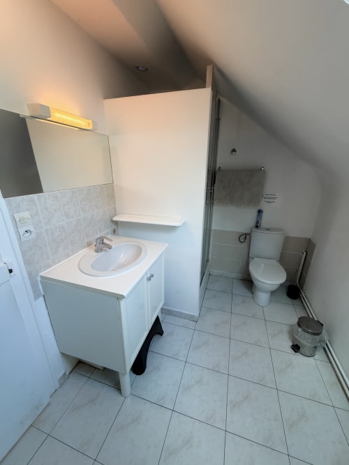 Modern bathroom at Les gites de Lereau with white sink vanity, toilet, and tiled flooring in Vallières-les-Grandes