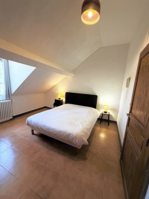 Cozy attic bedroom at Les gites de Lereau with white bed, skylights, and warm lighting in Vallières-les-Grandes