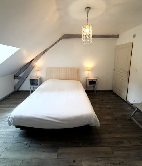 Modern attic bedroom at Les gites de Lereau with white bedding, pendant lighting, and wooden floors in Vallières-les-Grandes