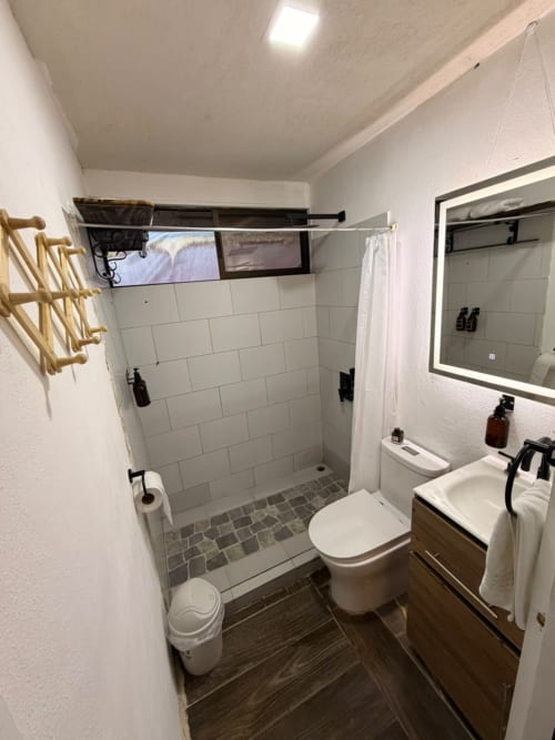 Baño moderno en villa Volcán Irazú de Chalets Vistas del Poás, Heredia con ducha tipo walk-in, lavamanos y sanitario
