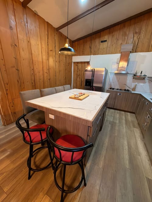 Moderno comedor y cocina en villa Volcán Irazú de Chalets Vistas del Poás, con encimera de mármol y acero inoxidable