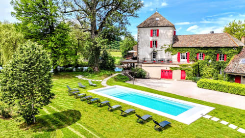 Le Moulin des Ducs, cottage de luxe à Épinac avec piscine, transats et bâtiments couverts de lierre