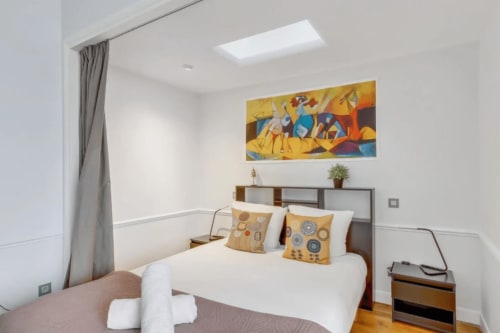 Modern bedroom at Résidence Aurmat boutique hotel in Boulogne with bed, colorful artwork, and skylight