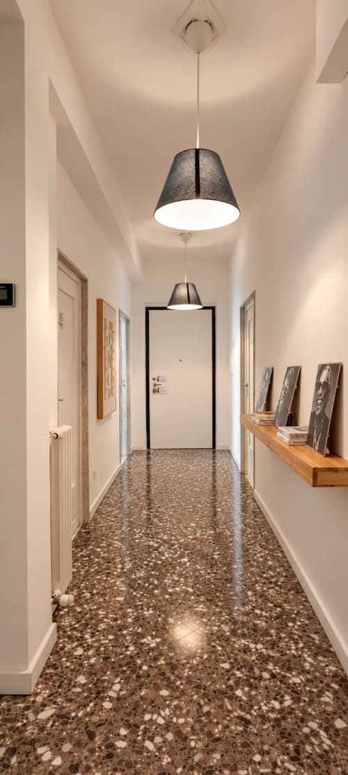 Corridoio moderno dell'appartamento Easystay Bari con pavimento in terrazzo, luci a sospensione, ripiano in legno e più porte