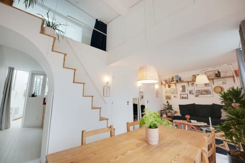 Appartement parisien moderne avec table à manger en bois, escalier, séjour et murs blancs - Montmartre