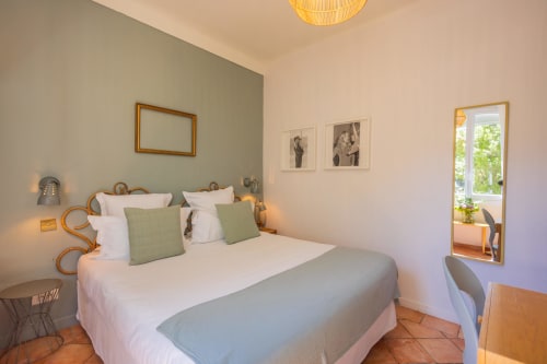 Chambre Double Standard de l'Hôtel Les Lauriers à Saint-Tropez, avec un mur d'accent vert sage, literie blanche et vue sur la ville