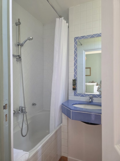 Salle de bain moderne avec vasque bleue, miroir et douche à l'Hôtel Les Lauriers à Saint-Tropez