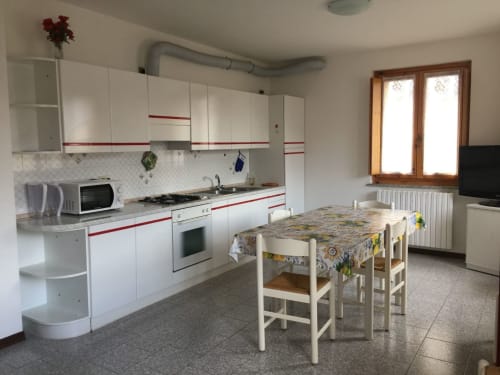 Cuisine-salle à manger spacieuse à l'appartement Quadrifoglio chez Gio Appartamenti, Aymavilles, avec mobilier blanc et table de repas