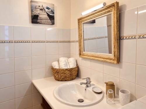 Lavabo et miroir encadré de bois de la salle de bain privative de la chambre Avel à Ty Coz Breizh, maison d’hôtes à Guidel, avec panier de serviettes et décoration marine.