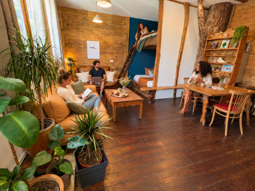 Salon commun chaleureux du gîte de Chaparon B&B à Lathuile avec poutres en bois, sièges confortables, plantes et vue montagne