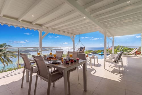 Villa avec vue océan, terrasse avec table à manger, chaises longues et piscine à débordement surplombant Le Marin, Martinique