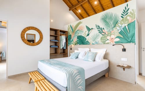 Chambre moderne de la villa aux Terrasses du Morne Gommier avec papier peint botanique tropical, lit blanc, détails en bois et vue sur mer