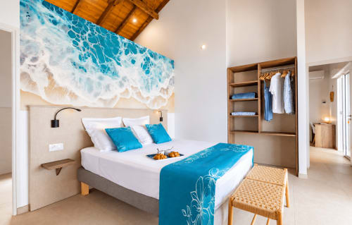 Chambre de villa en bord de mer avec art vagues océan, accents bleus, armoire en bois et vue sur la mer aux Terrasses du Morne Gommier
