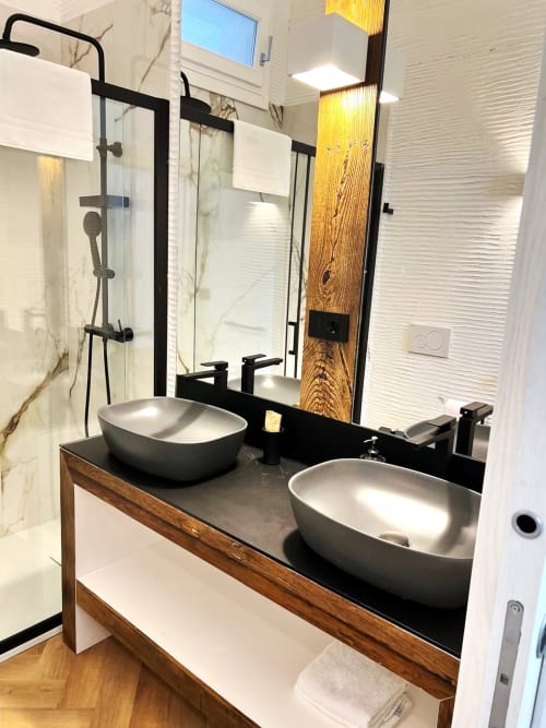 Bagno moderno del La Sciumara Resort Palau con doppi lavabi, rubinetteria nera, mobile in legno e doccia in vetro