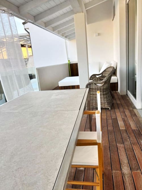 Veranda privata del Resort La Sciumara a Palau con terrazza in legno, sedie in vimini e ringhiere bianche affacciata sul giardino