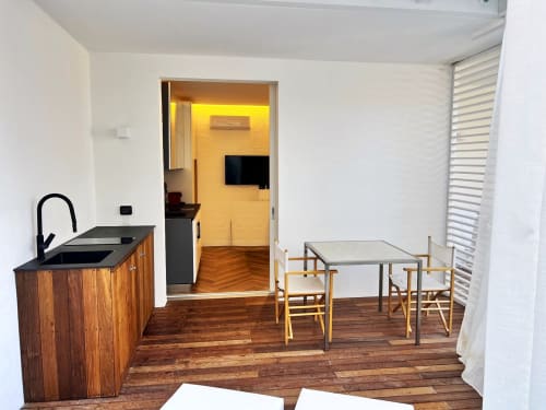 Cucina moderna e zona pranzo nell'appartamento di Palau con pavimenti in legno, angolo cottura, tavolo e accesso al salotto