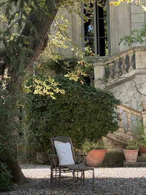 Coin salon privé à Domaine de Montlaur B&B, entouré de murs en pierre couverts de lierre et de plantes en pots