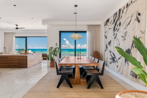 Modern Casa Copal cottage dining area with ocean views, wooden table, black chairs, and beachfront scenery in Isla Mujeres