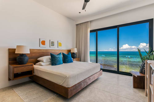 Modern beachfront bedroom with ocean views at Casa Copal, Isla Mujeres - wood bed, blue pillows, sea view terrace