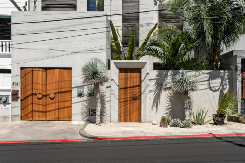 Casa Copal cottage exterior in Isla Mujeres with white walls, orange doors, and tropical plants