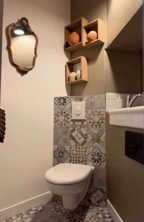 Salle de bain contemporaine à Les anciennes écuries du Château avec carrelage à motifs, étagères murales et miroir orné