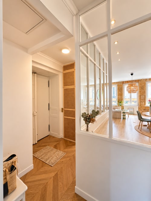 Couloir moderne avec portes vitrées coulissantes chez Mattbnb Metz, donnant sur la salle à manger aux planchers en bois