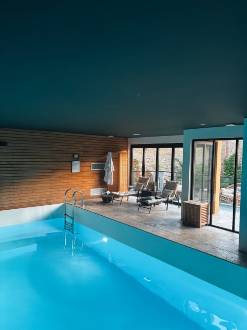 Indoor swimming pool at La Maison d'Augustin B&B in Mont-de-Marsan with wooden walls and terrace access