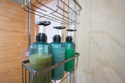 Estantería cromada de baño con artículos de higiene verde en Haus Holiday Homes, San Pedro del Pinatar