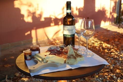 Tagliere di vini e formaggi al tramonto presso La Casa dei Tigli B&B a Cannara, Italia, con vista sui vigneti
