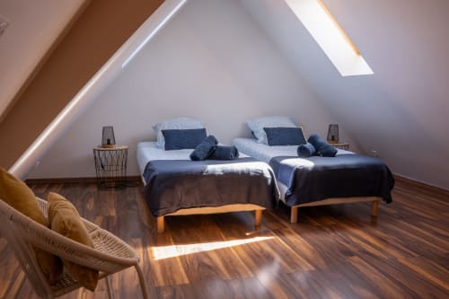 Dormitorio luminoso en la casita Les Ambrades de Colmar con dos camas individuales, tragaluz, piso de madera y mobiliario moderno