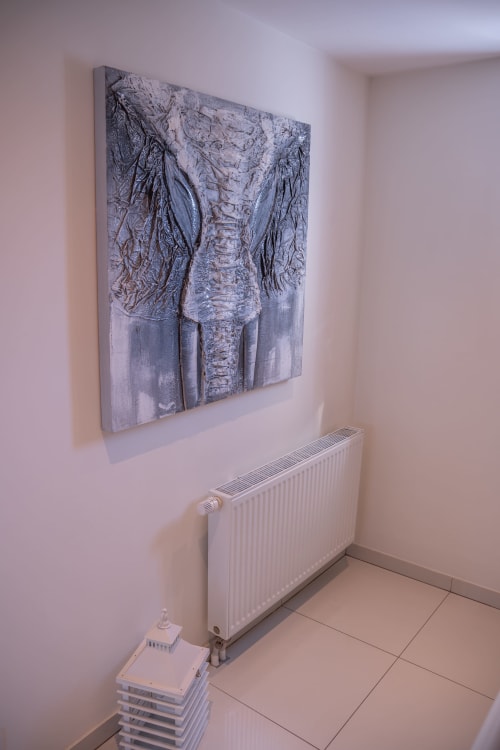 Habitación cottage moderna en Les Ambrades Colmar con obra de arte de elefante contemporáneo sobre radiador blanco y piso de baldosas