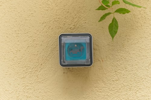 Timbre con etiqueta azul en pared color crema de la casa rural Les Ambrades en Kaysersberg-Vignoble