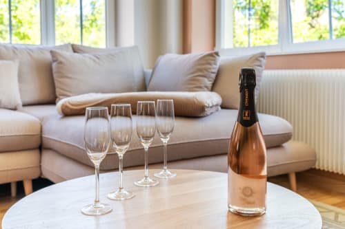 Elegante sala de estar en la casa rural Les Ambrades con botella de champagne y copas sobre mesa de mármol, Kaysersberg Vignoble