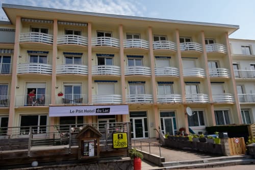 Le Petit Hôtel du Lac en Gérardmer con fachada melocotón, balcones blancos y ubicación junto al lago