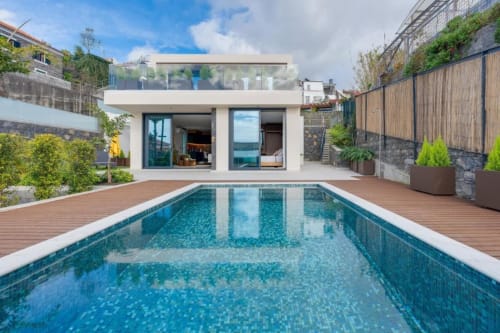 Piscina moderna da villa BHF Residences Luxe Family em Arco da Calheta, Portugal, com água turquesa e design contemporâneo branco