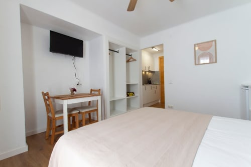 Amplio loft en Apartamentos El Sol II en Tossa de Mar con cama, escritorio, TV, cocineta y comodidades modernas