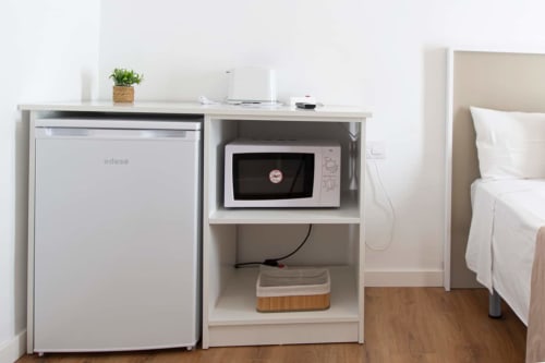 Pequeña kitchenette en el Loft 304 de Apartamentos El Sol II, Tossa de Mar, con microondas, mini nevera y muebles blancos
