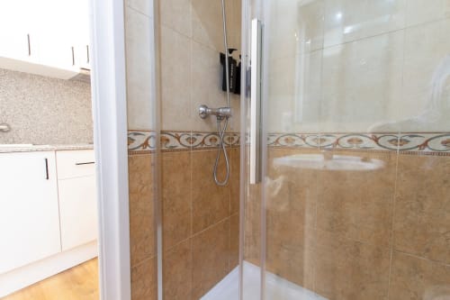 Moderno baño de ducha con azulejos beige y cenefa decorativa en Apartamentos El Sol II, Tossa de Mar