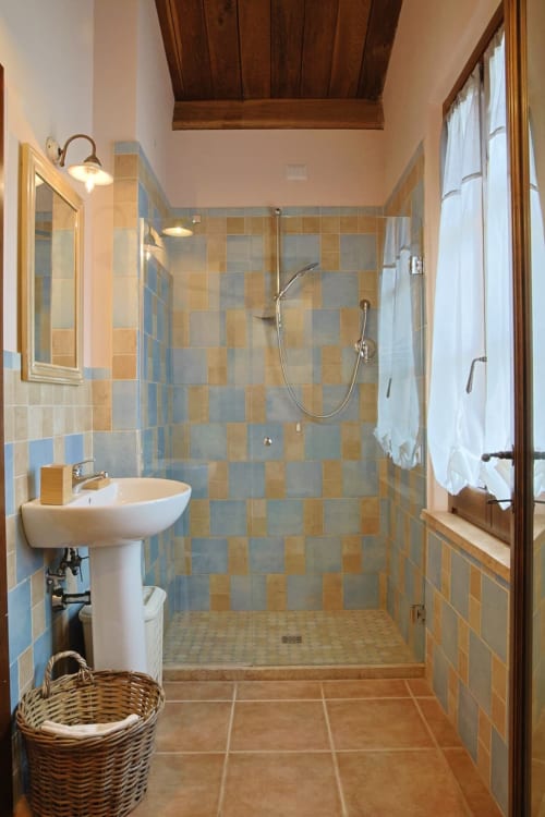 Bagno moderno con cabina doccia, lavabo a colonna e rivestimento in piastrelle blu-beige presso La Casa dei Tigli B&B a Cannara