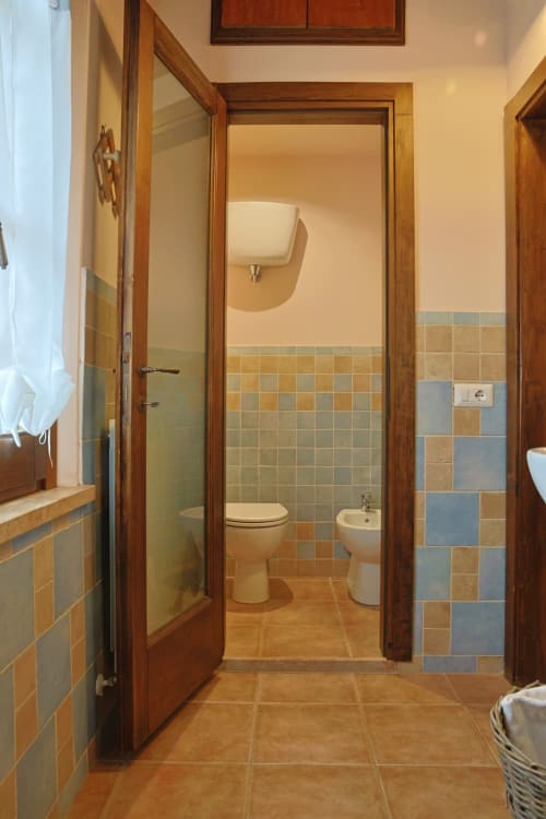 Bagno della Casa dei Tigli BnB a Cannara con pareti piastrellate, WC, bidet e doccia
