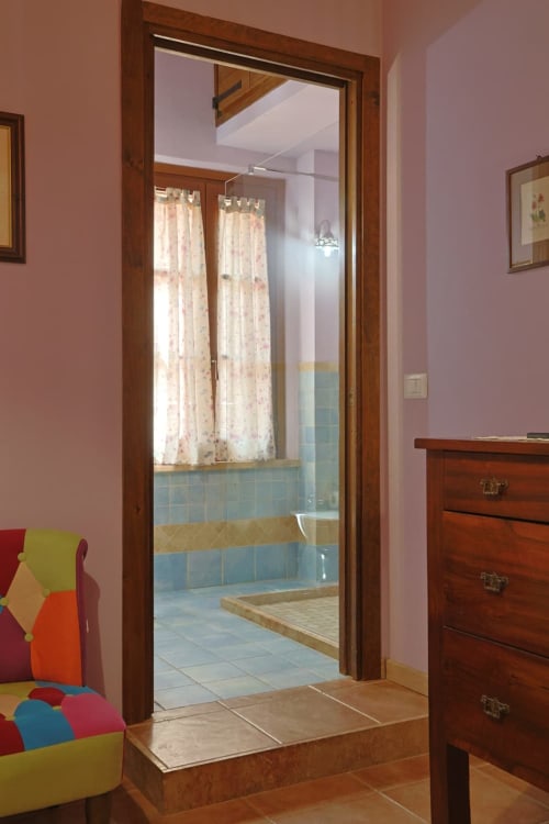 Ingresso dell'appartamento Malva a La Casa dei Tigli B&B a Cannara, che si apre su un bagno con piastrelle blu e luce naturale