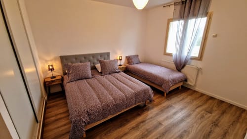 Chambre avec lits double et simple, mobilier en bois et lumière naturelle au gîte Vindihouses à Magnien, France