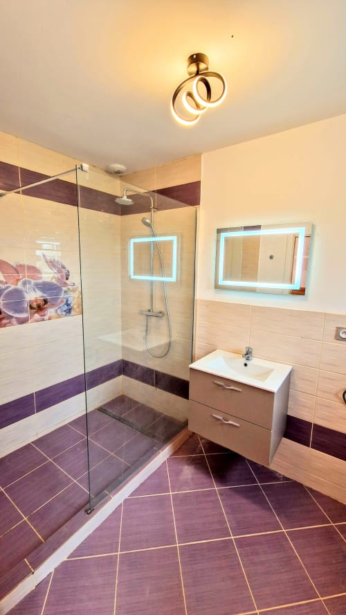 Salle de bain moderne avec douche à l'italienne, vue sur la piscine chauffée et équipements contemporains du gîte Vindihouses à Magnien